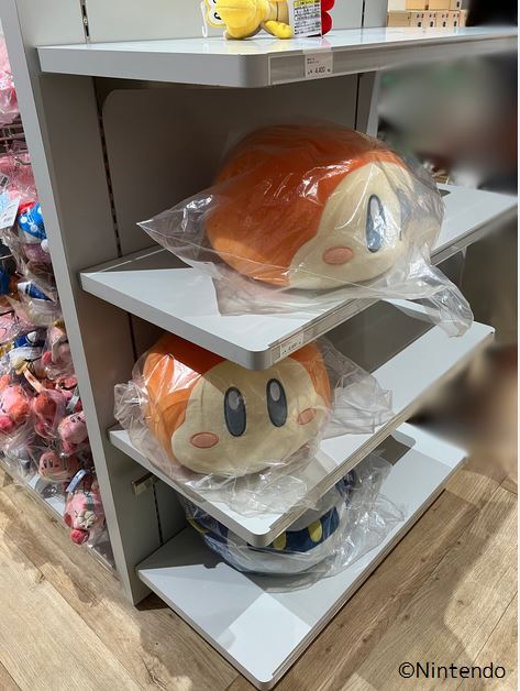 Nintendo TOKYOの店内にある星のカービィの商品棚。側面の棚にワドルディとメタナイトのぬいぐるみが置かれている。右下に©Nintendo